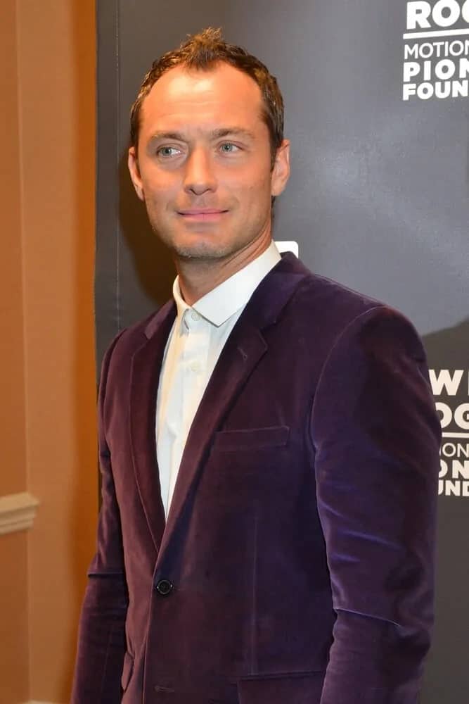 Jude Law sported his signature hairstyle of stylishly spiked hairstyle with curls and highlights at the Pioneer Dinner during CinemaCon 2015 at Caesar's Palace in Las Vegas, Nevada.
