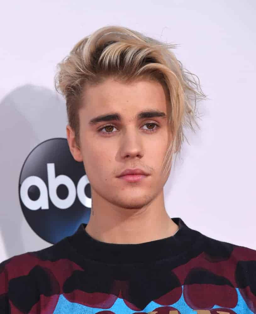 Justin Bieber dyed his hair golden blonde and styled a lengthy look when he appeared at the American Music Awards 2015 in Los Angeles, CA.