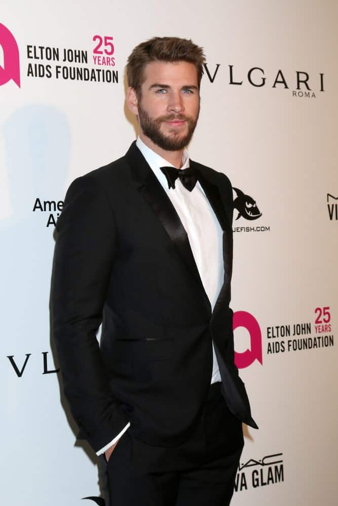 Liam Hemsworth was spotted at a 2018 Elton John AIDS Foundation Oscar Viewing Party last March 4, 2018 in a classic black suit and his short hair side-parted with some spikes in front.