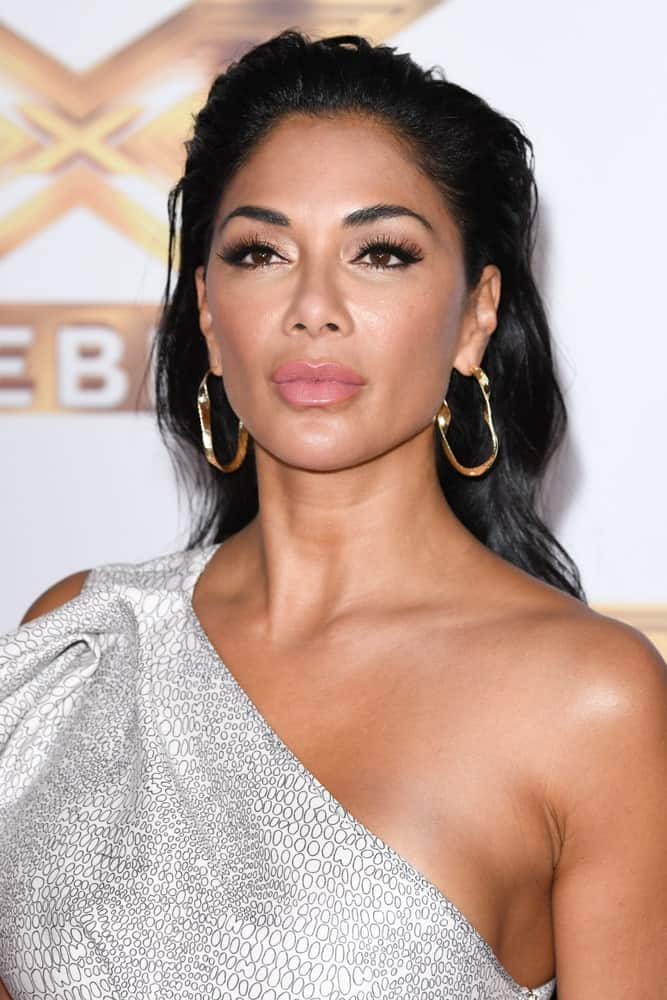 Nicole Scherzinger looked ravishing in a halter dress and gold hoop earrings accentuated by her slicked back hair. This was worn during the photocall for "The X Factor: Celebrity", London held on October 9, 2019.
