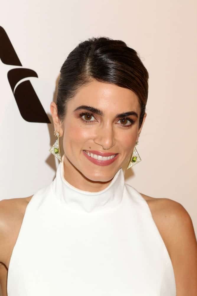 The actress exhibited a neat side-swept updo at the Elton John Oscar Viewing Party on the West Hollywood Park on February 24, 2019. She completed the look with a white halter dress and gorgeous triangular earrings.