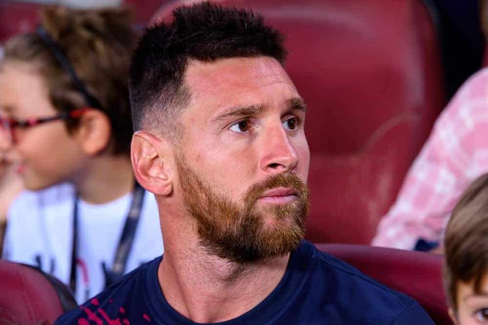 Lionel Messi sat with the spectators at the La Liga match between FC Barcelona and Real Betis at the Camp Nou Stadium on August 25, 2019 in Barcelona, Spain. He wore a sports shirt with his short and spiked fade hairstyle.