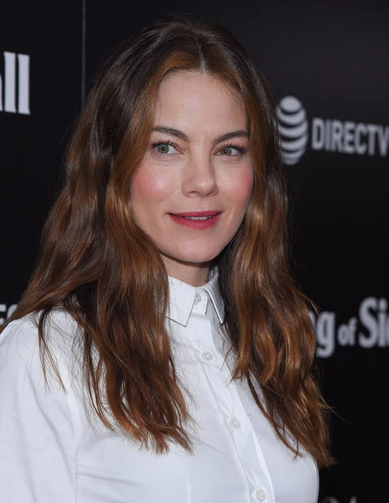 Michelle Monaghan arrives for the "The Vanishing of Sidney Hall" LA Screening on February 22, 2018 in Hollywood, CA with a tousled and relaxed hairstyle that has auburn highlights. These stand out against her stark white blouse and dazzling smile.