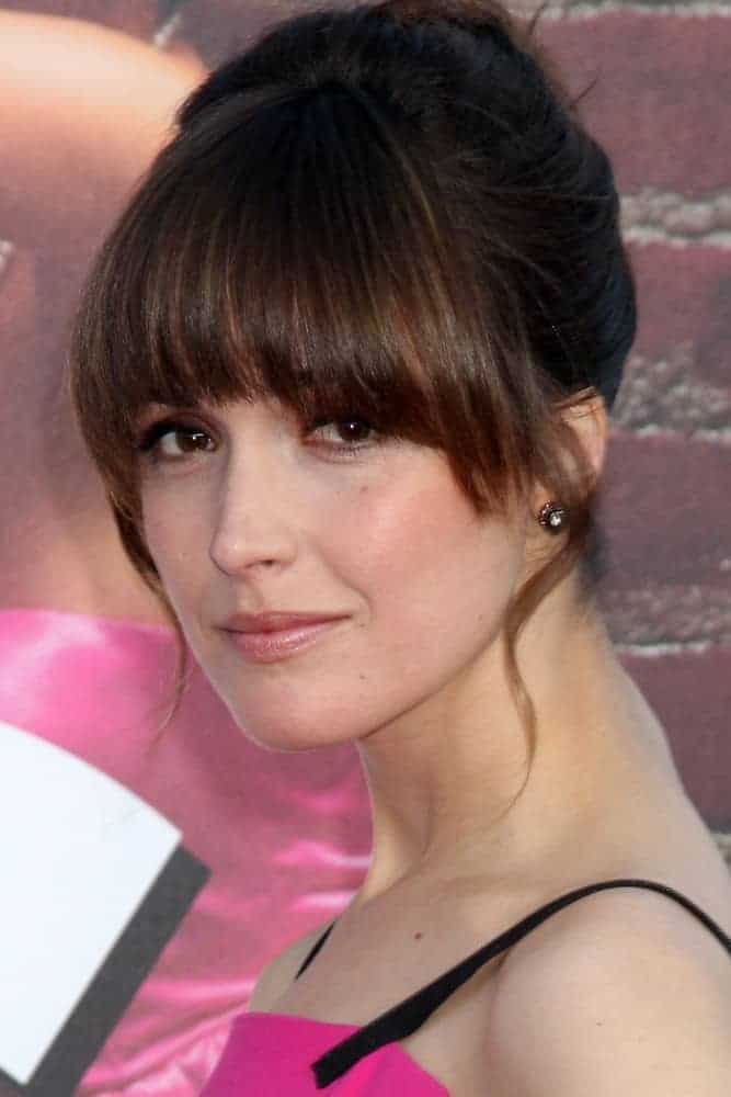 Rose Byrne was at the "Bridesmaids" Premiere at Village Theater on April 27, 2011, in Westwood, CA. She paired her pink dress with an upstyle bun hairstyle with blunt bangs and loose tendrils.