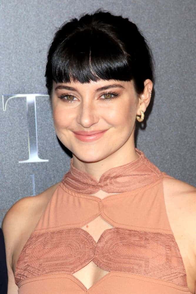 Shailene Woodley was at the 2018 CinemaCon - An Evening With STXfilms at Colosseum in Caesars Palace on April 24, 2018, in Las Vegas, NV. She wore a stunning beige dress with her raven upstyle bun hairstyle incorporated with blunt bangs.