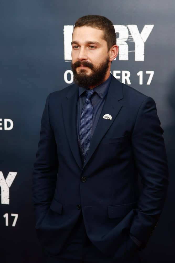 The actor's curls were reigned in with a short classic hairstyle complemented with a thick beard when he attended the world premiere of "Fury" at the Newseum on October 15, 2014 in Washington DC.