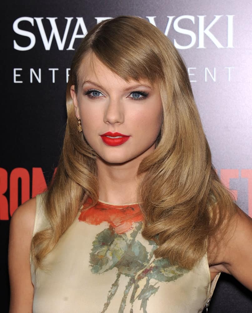 Taylor Swift showed off her straight blonde hair with big curls on the ends along with short side bangs at the "Romeo & Juliet" World Premiere held on September 24, 2013.
