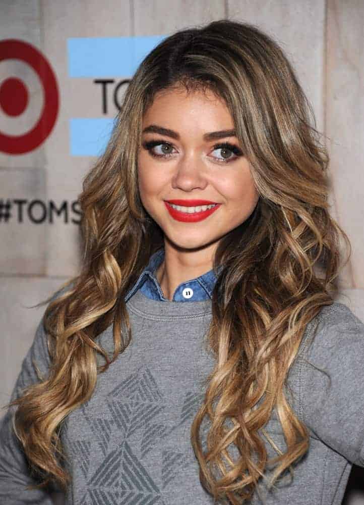 Sarah Hyland attended the TOMS for Target Partnership Celebration on November 12, 2014, in Culver City, CA. She was seen wearing a smart-casual outfit to pair with her long and wavy highlighted sandy blonde hairstyle with layers and slight tousle.