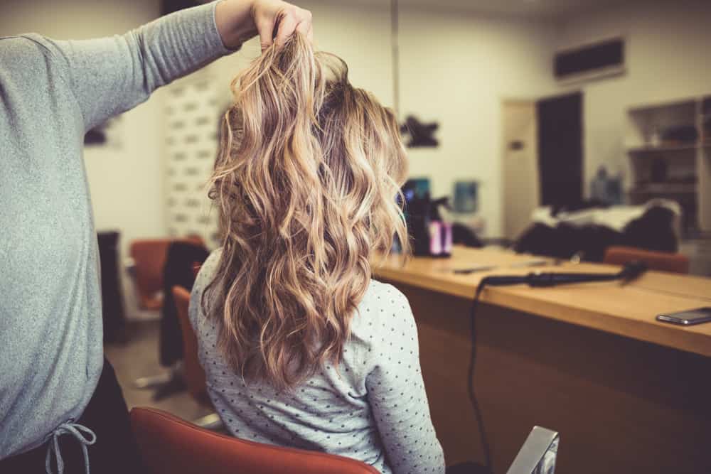 Woman getting balayage coloring technique done to hair.