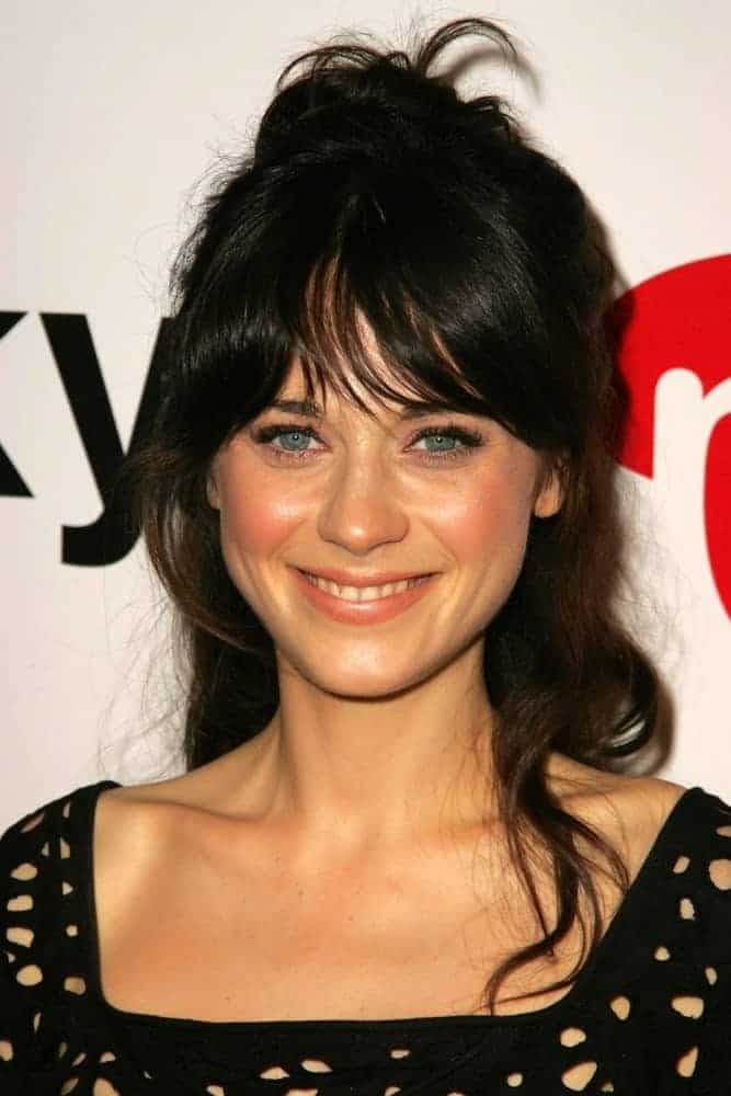 Zooey Deschanel was at the Lucky Magazine LA Shopping Guide Party on August 10, 2006, in Milk, West Hollywood, CA. She was charming in a black dress and messy tousled raven hairstyle with bangs and a bun.