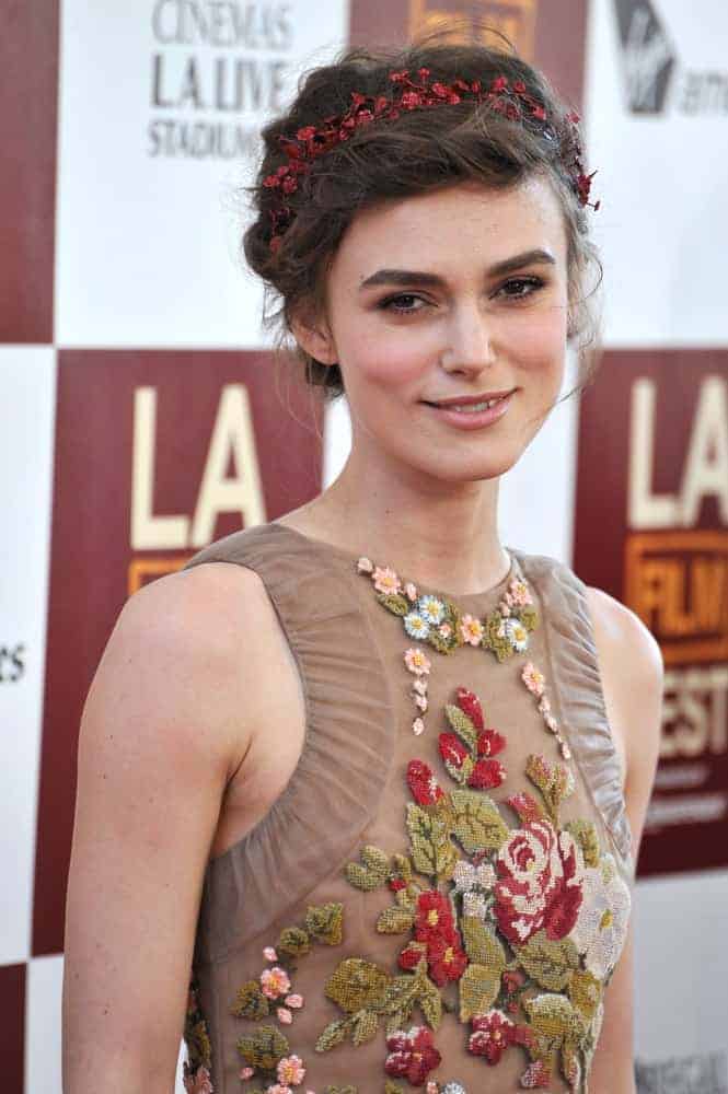 Keira Knightley was at the world premiere of her movie "Seeking a Friend for the End of the World" at the Regal Cinemas LA Live on June 19, 2012, in Los Angeles, CA. Her floral dress paired well with her loose and messy braided hairstyle with a bun, a hairband, and loose tendrils on the sides.