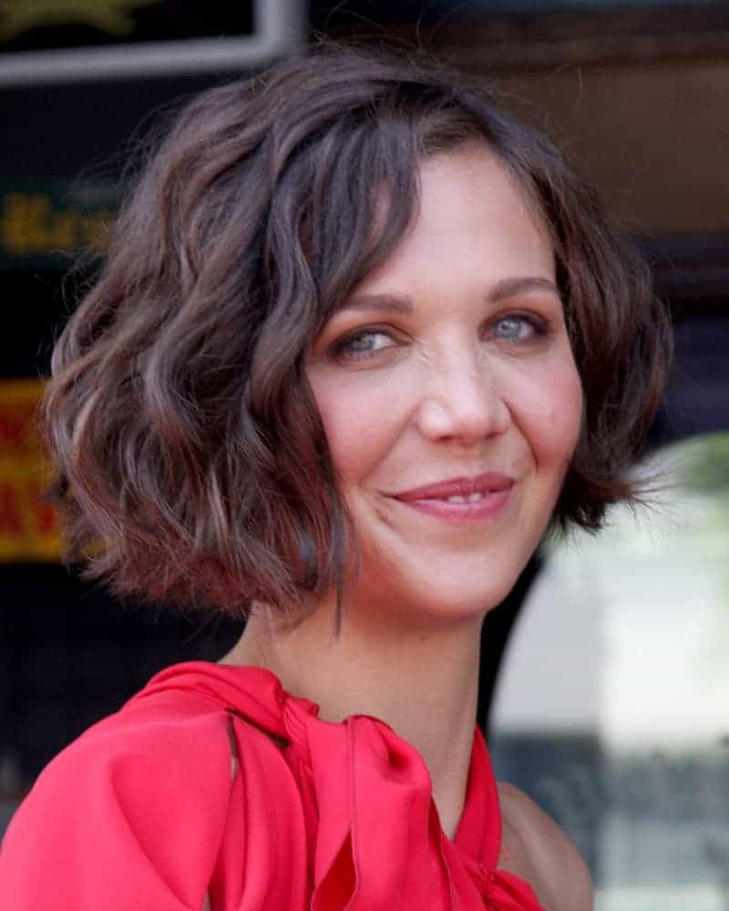 Maggie Gyllenhaal attended the Hollywood Walk of Fame Ceremony for Emma Thompson at Hollywood Walk of Fame on August 5, 2010 in Los Angeles, CA. She wore a charming red dress and paired with a shin-length curly brown hairstyle with a slight tousle.