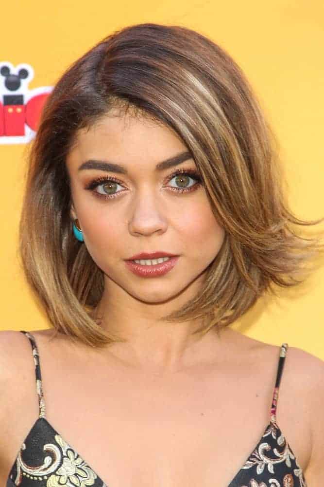 On November 14, 2015, Sarah Hyland attended the premiere of Disney Channel's 'The Lion Guard: Return Of The Roar' at Walt Disney Studios. She came wearing a simple black dress with a sandy blonde shoulder-length hairstyle with flippy bangs on one side.