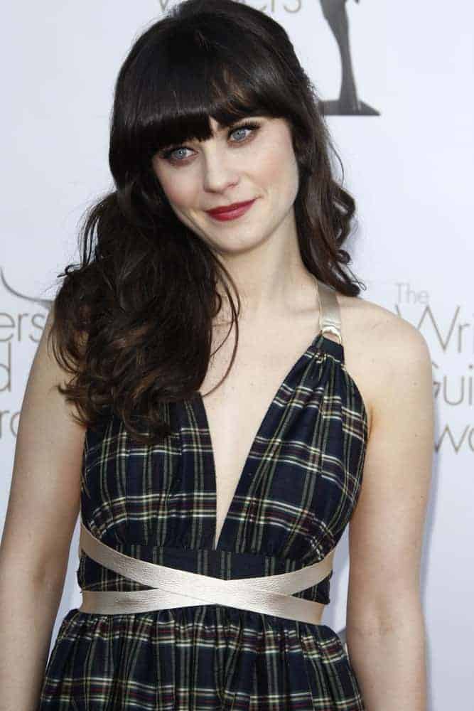 Zooey Deschanel attended the 2012 Writers Guild Awards at The Hollywood Palladium on February 19, 2012, in Los Angeles, California. She paired her lovely sundress with a side-swept curly brunette hairstyle that has blunt bangs.