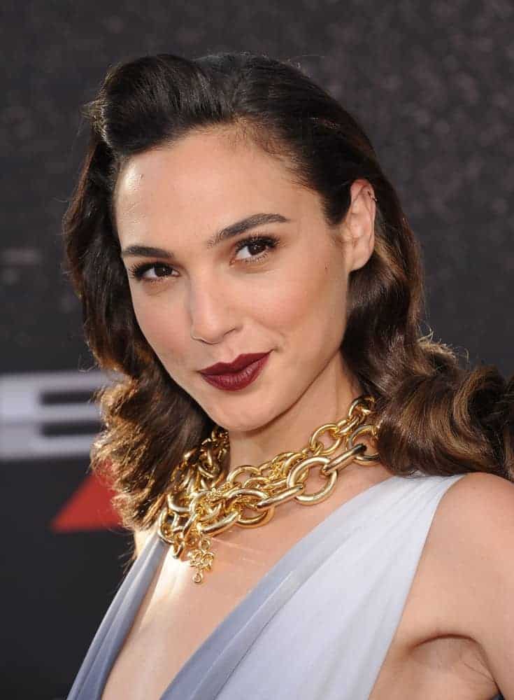 Gal Gadot attended the "Fast & Furious 6" US Premiere on May 21, 2013, in Hollywood, CA. She wore a golden chain accessory to match her vintage curly hairstyle with a pompadour finish.