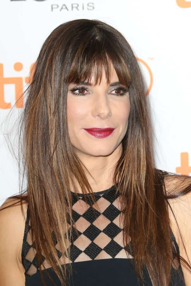 Sandra Bullock with long straight light brown hair with bangs.