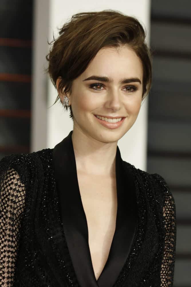 Lily Collins in a fresh and short haircut, swept to one side.