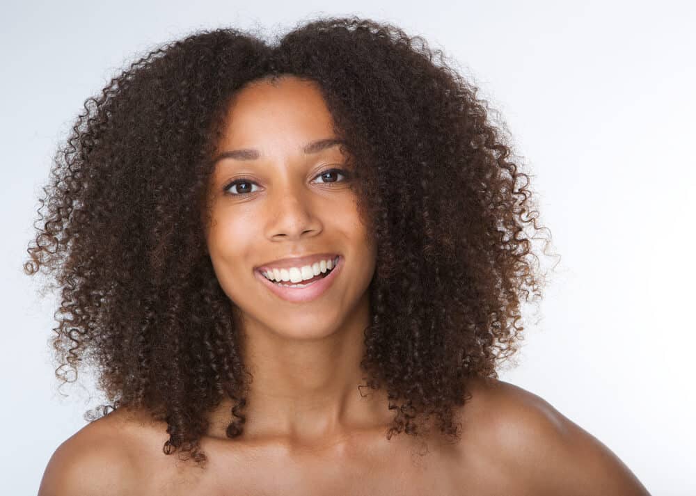 Coily-haired woman flashing her beautiful smile.