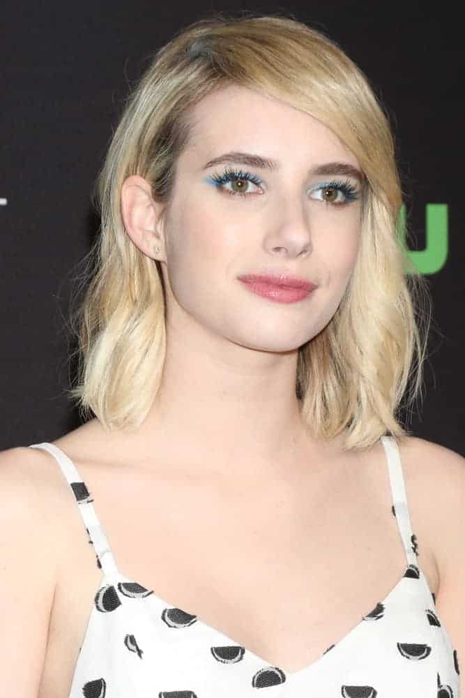 Emma Roberts attended the PaleyFest Los Angeles for Scream Queens at the Dolby Theater on March 12, 2016, in Los Angeles, CA. She paired her white patterned smart casual outfit with her shoulder-length tousled blonde hairstyle with layers and side-swept bangs.
