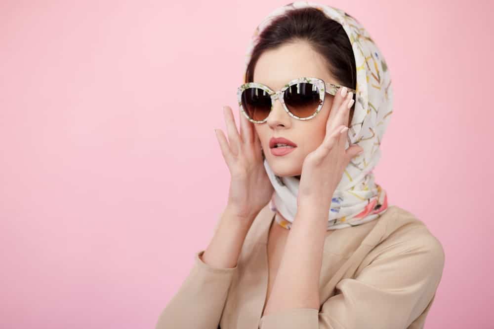 woman in a sunglasses wearing a scarf.