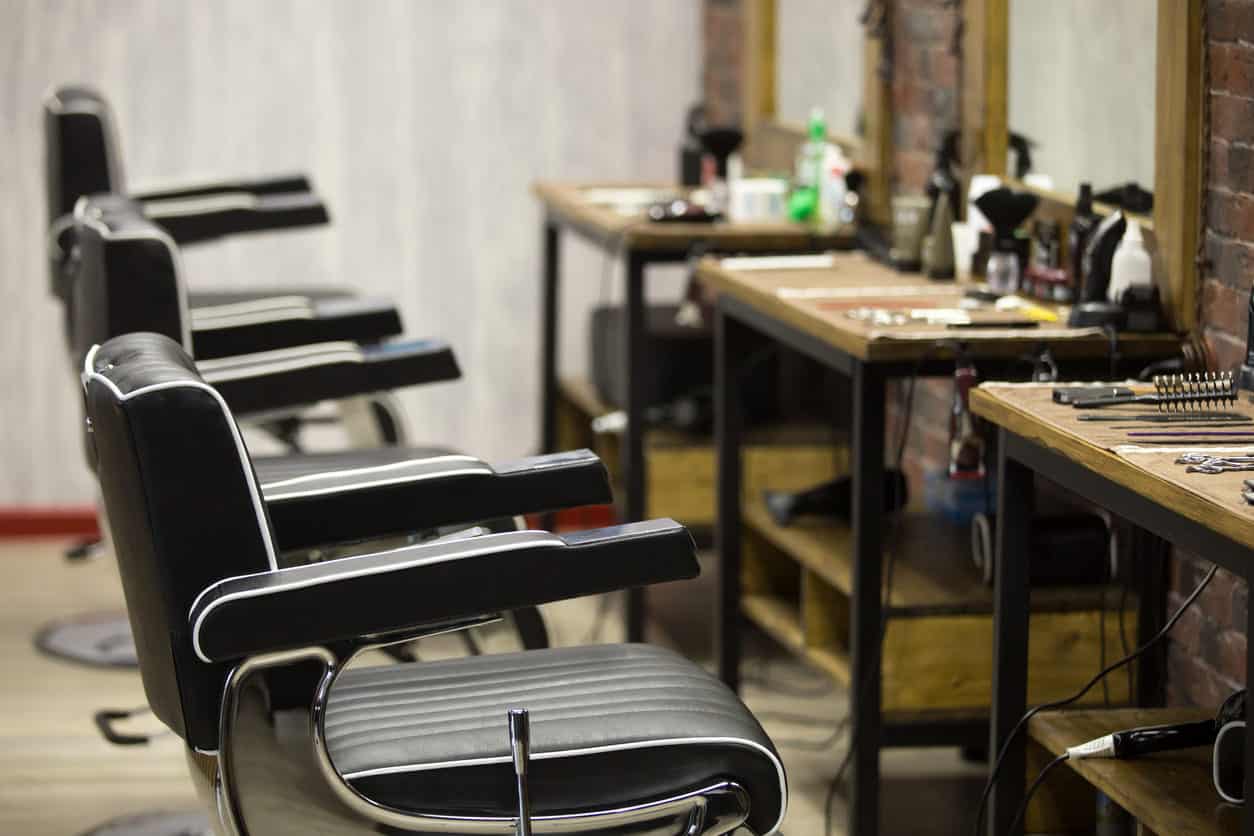 I like the individual barber stations which look aged (probably are) along with mirrors mounted on brick wall. The black and white barber chairs look good too.