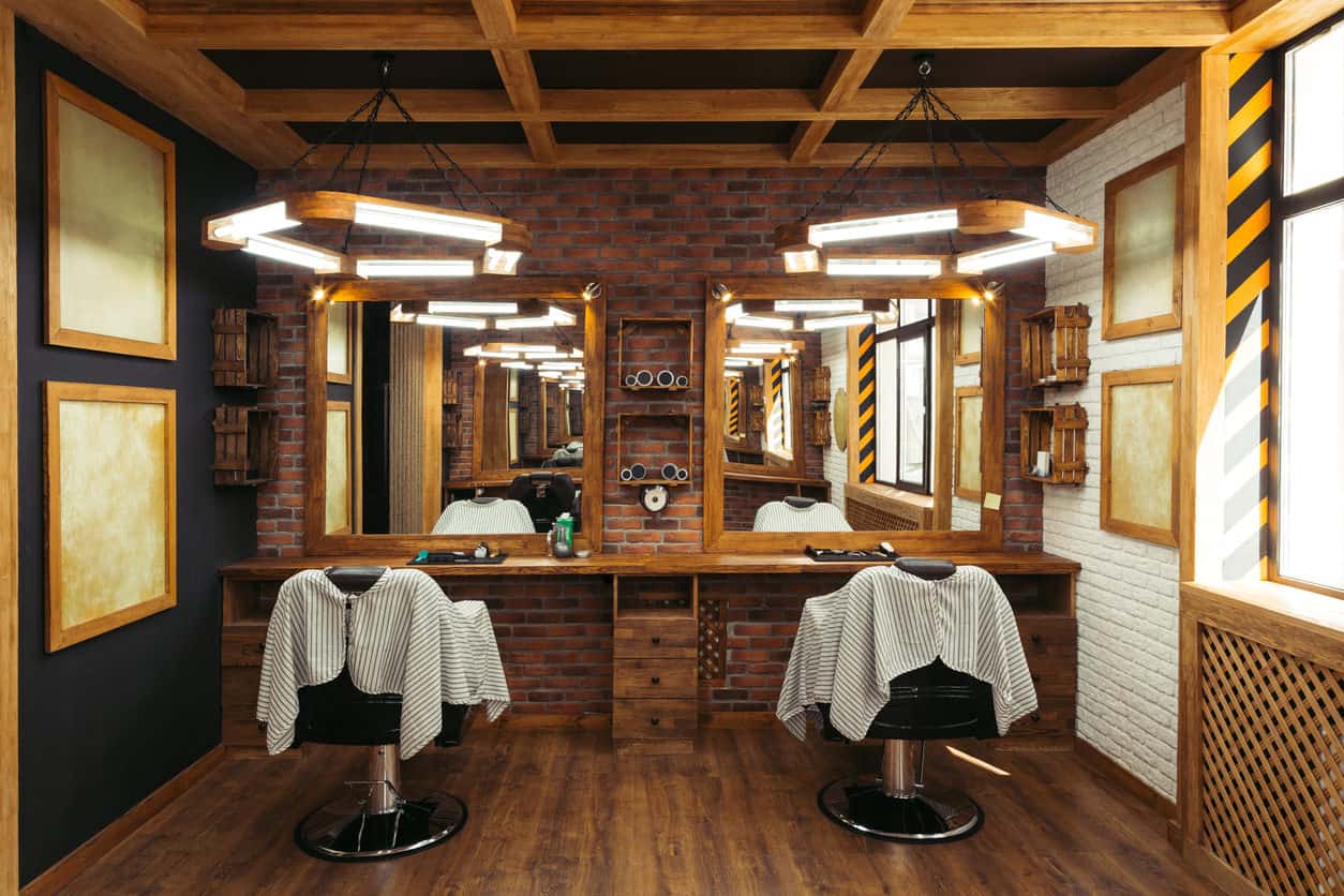 Another rustic, masculine design. I love the suspended wood lights. Those are definitely custom. Check out the coffered beamed ceiling which goes well with the brick and wood flooring. Great design for a small barber shop space.