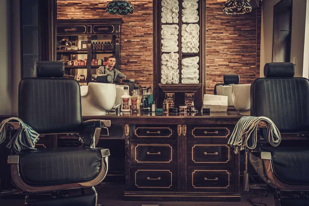 Now we're talking pure vintage old school barber shop design. Look at the detail with those dark cabinet cutting stations along with the old school chairs (which are new, but look old). The brick wall, towel shelf and so much more. This is a truly inspiring barbershop interior.