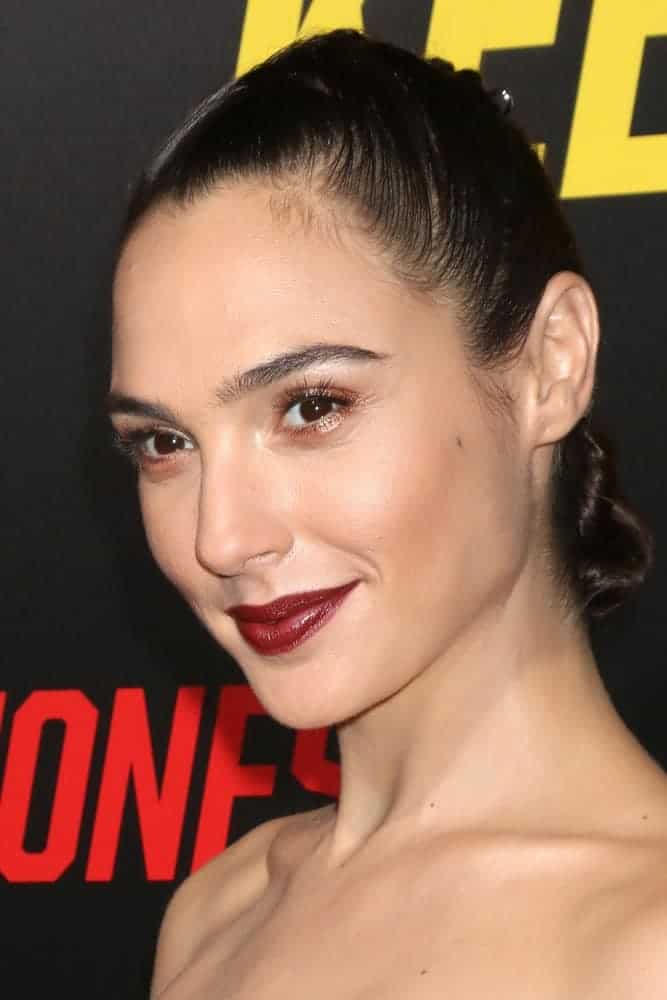 Gal Gadot was at the "Keeping Up with the Joneses" Red Carpet Event at the Twentieth Century Fox on October 8, 2016, in Los Angeles, CA. She paired her dark red lips with a slick raven bun hairstyle.