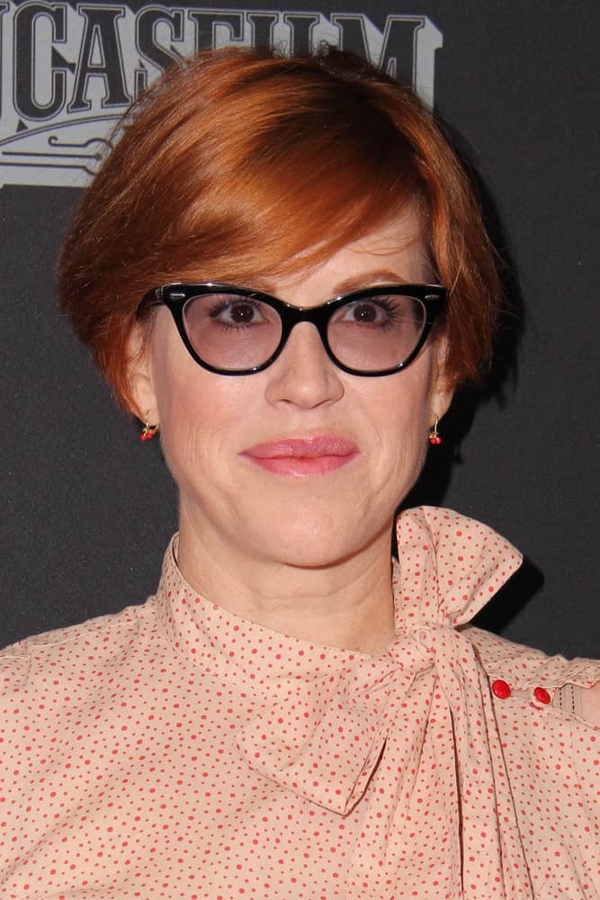 Molly Ringwald shows us how side swept bangs and a short bob are a great combination for copper haired folks who wear glasses.