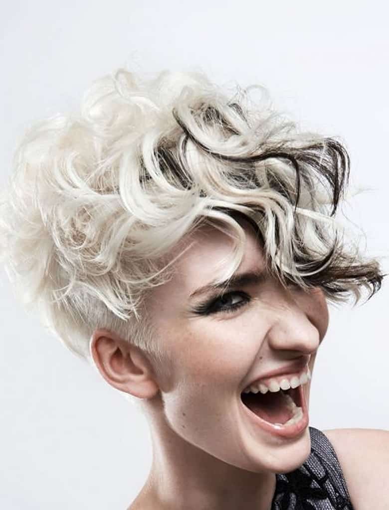 This wonderful hairstyle is super-short, almost shaved at the back. However, the top and front are comparatively quite long and can be styled into tousled, loose curls. Coupled with the black and silver hair color, this style has a very grunge look.