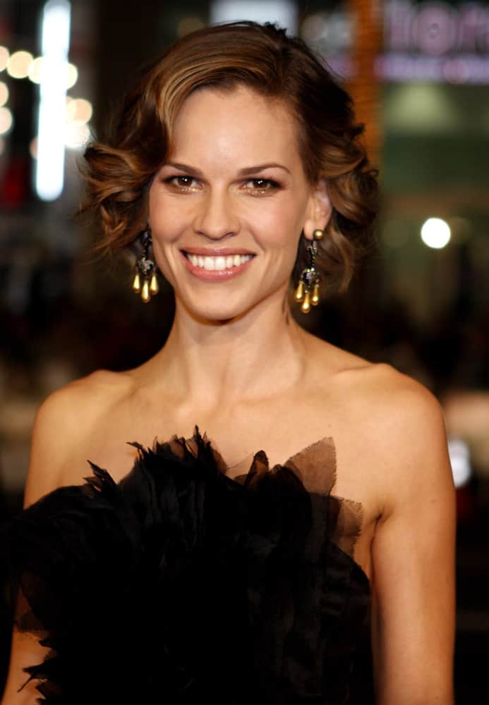 Hilary Swank’s short curls look like a dream. The actress styled her hair in elaborate curls and gave them a hint of gold for the premiere of her movie “P.s. I Love You.”