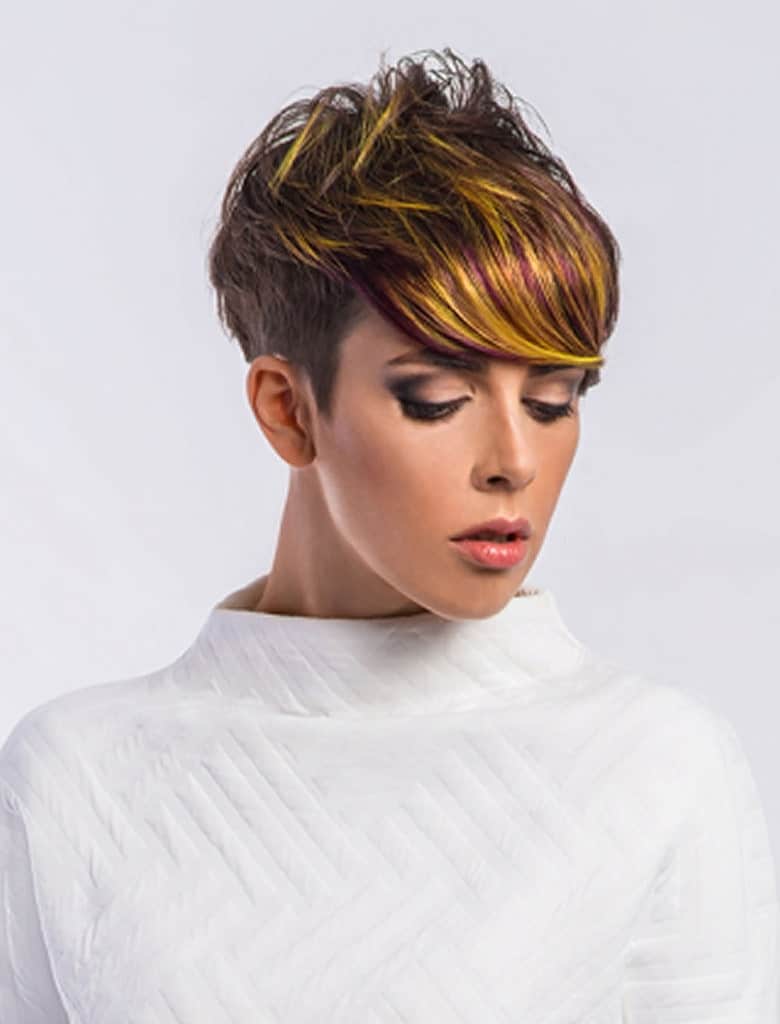 This haircut has long bangs on the front that reach the eyebrows. The back is quite short though and the top of the pixie cut is fluffed up to give a posh yet casual look.