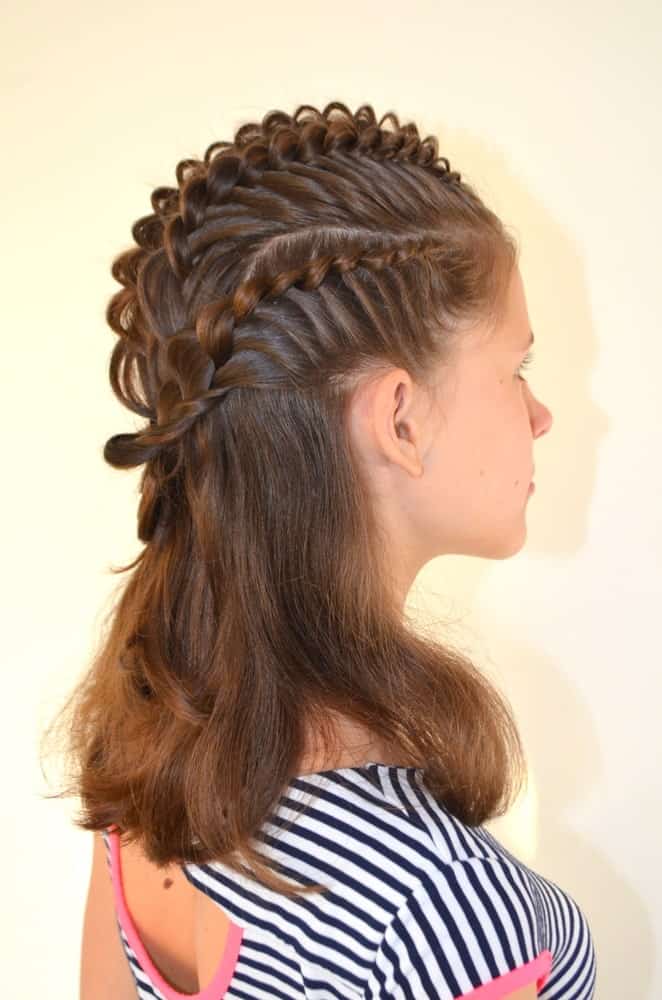 This hairstyle has tight French braids running along the side and top of the girls head. It adds a lot of height to the crown of the head and looks edgy and stylish. 