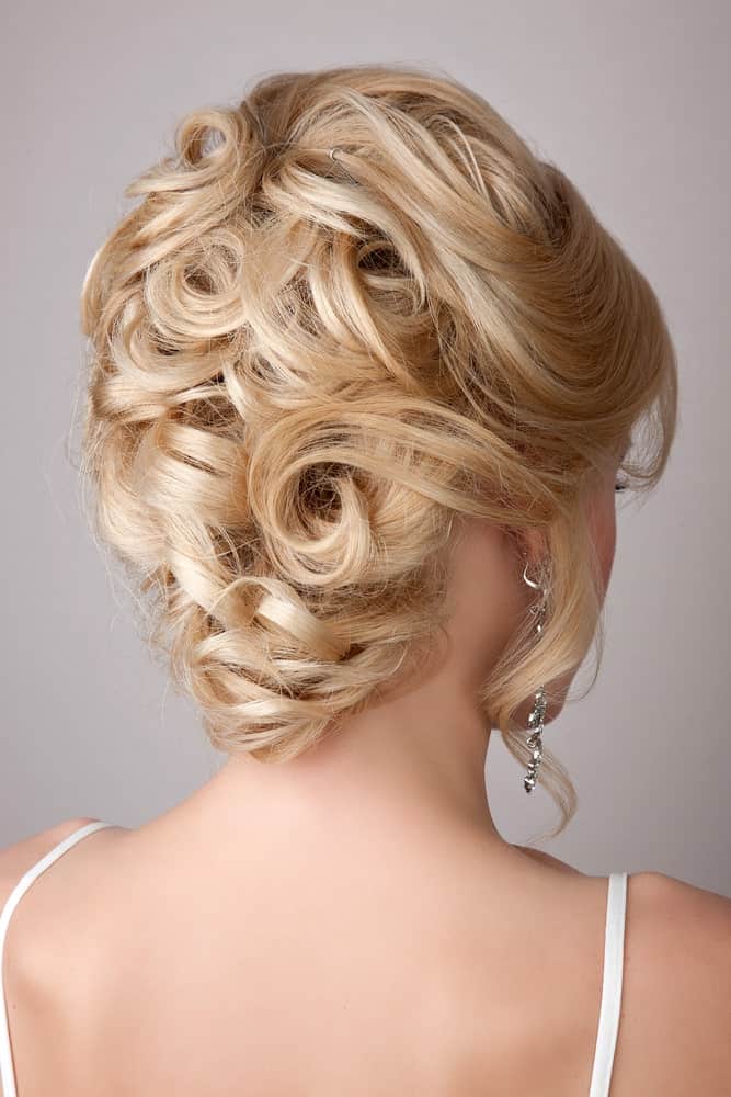 This gorgeous hairstyle mimics a rose bouquet. With lots of inwards twists and curls, this beautiful updo looks extremely flattering on every shade of blonde.