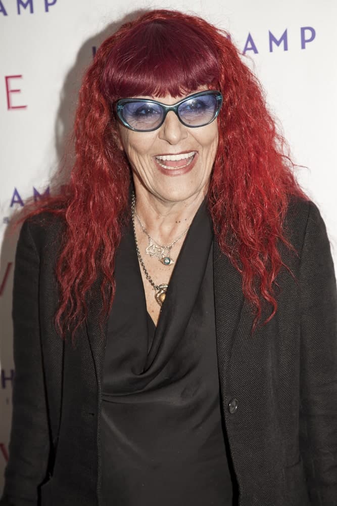 Long red curly hair seems to be working well for Patricia Fields. The best part about this look is that the glasses and the hairstyle can be equally appreciated, both making a strong impact on the overall appearance. To complete the look, add heavy front fringes to the equation. 