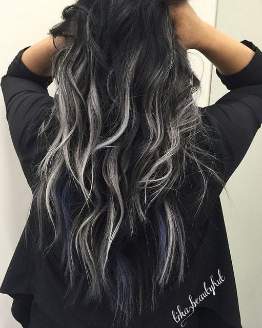 One of the biggest fashion trends these days is silver hair. This young woman has incorporated silver-blond balayage highlights in her naturally black wavy hair, giving her a very cool, uber-modern look.
