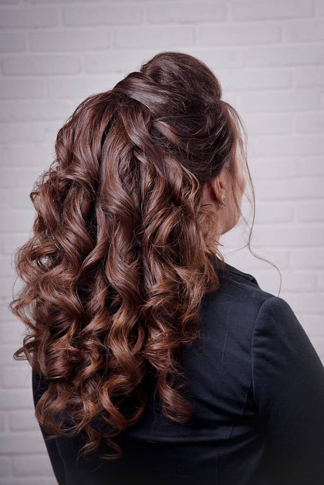 Another option for half up half down hairstyles is this sleek hairdo that keeps the backcombed bun simple but adds tons of volume with teased curls. 