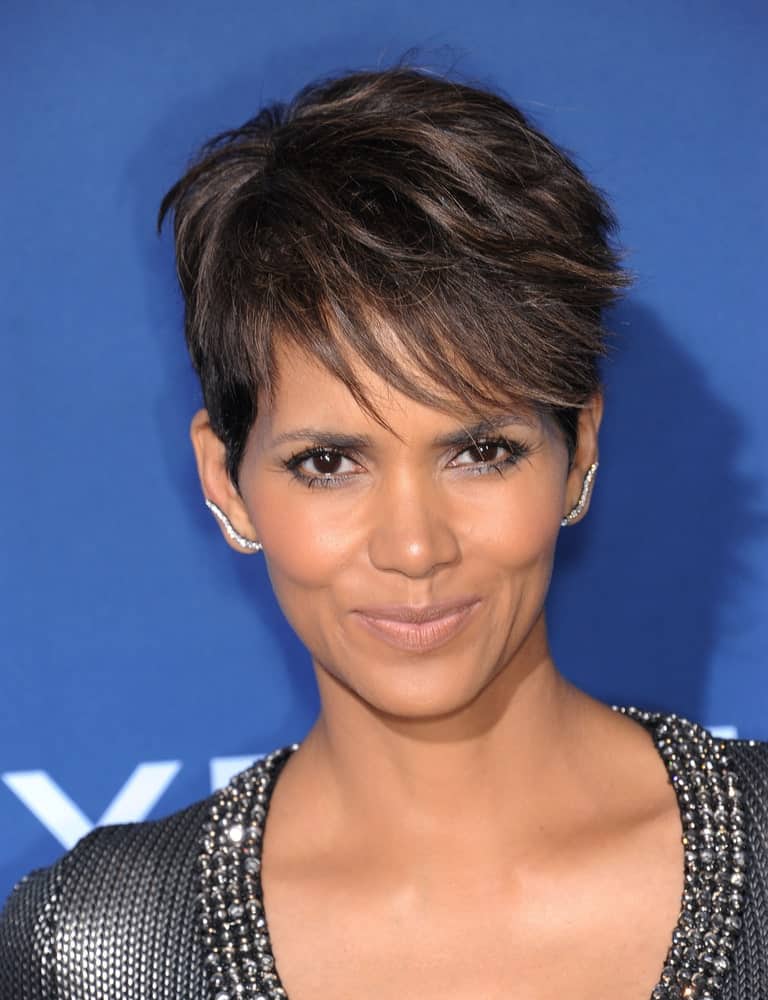Halle Berry’s textured and wispy pixie hair cut is all thanks to her beautiful naturally curly hair. The actress has kept her bangs long in the front and short on the sides for an edgy look.
