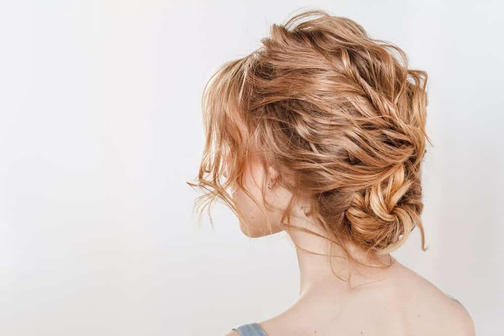 If you want an updo but don’t want braids, try this hairstyle. With messy waves and carefree bangs, it’ll make you look effortlessly stylish while keeping your hair behaving through all that dancing. 