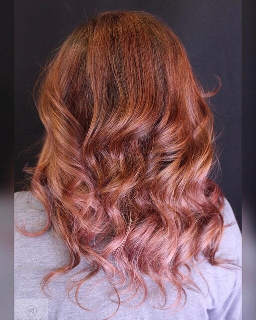 A very unique shade of red, this balayage incorporates the natural autumn red colors but also give a hint of strawberry pink to the end.