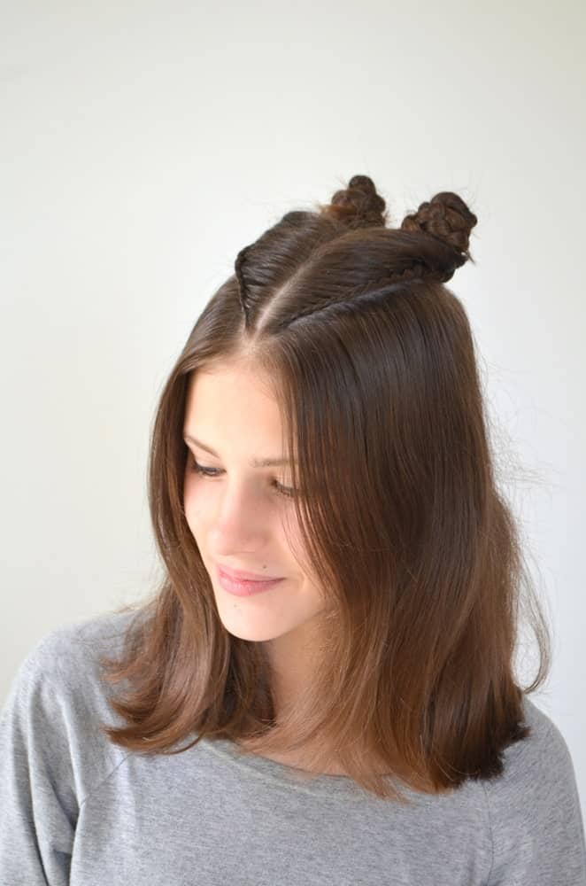 Adding a twist to the classic top knot, this hairstyle sweeps up the hair from the crown for two small top knots, leaving the rest of the hair flowing loose. It’s trendy, simple, and easy to do yourself. 