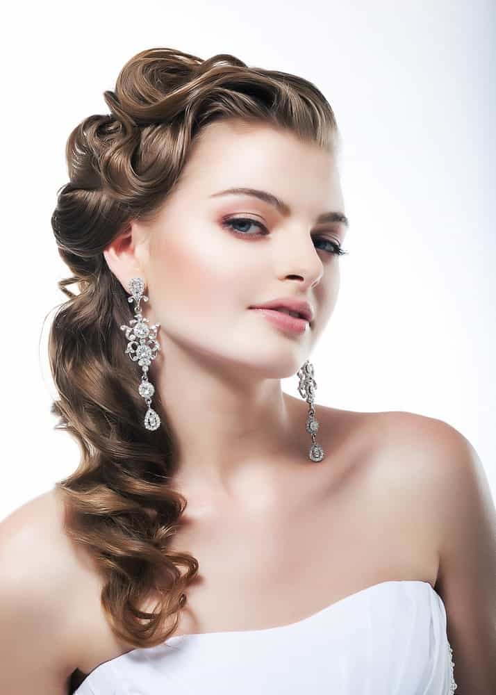 Though this may be a bridal hairdo, we think it will look absolutely stunning at a prom. The curls are more defined and elegantly bundled to the side for a soft finish that looks very old Hollywood. 