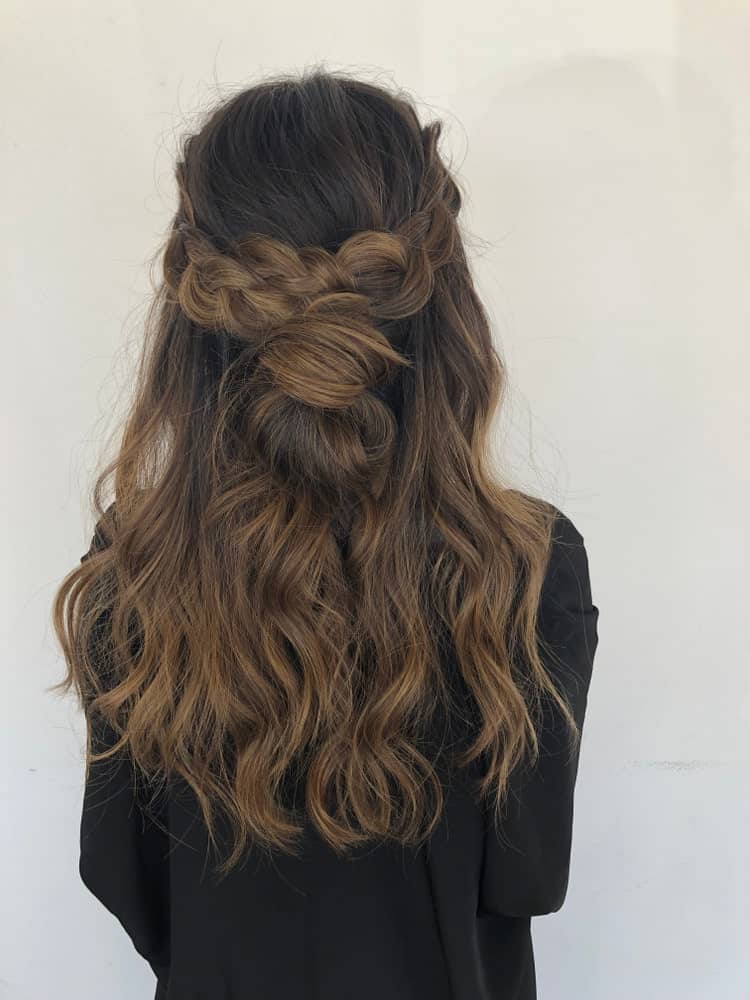 This beautiful balayage is a mix of very dark shades of brown. The crown braid styling highlights the gradient of colors in the woman’s hair.