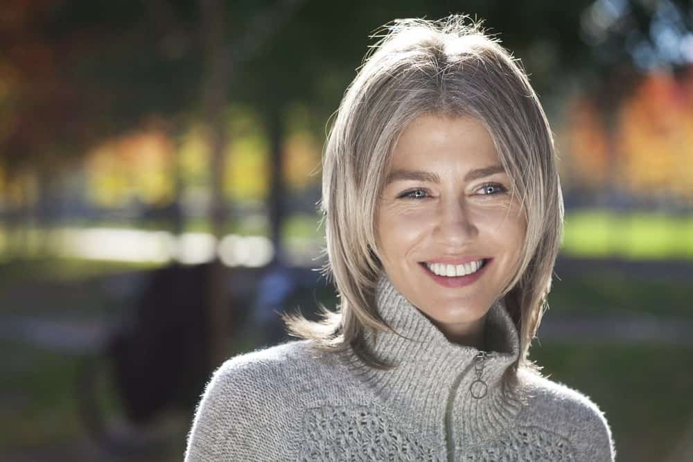 The color silver is not just for aging women; it looks great on young, fashion forward women as well. Take a look at this balayage with subtle silver highlights on ash blonde hair. The look makes this woman look so much younger.