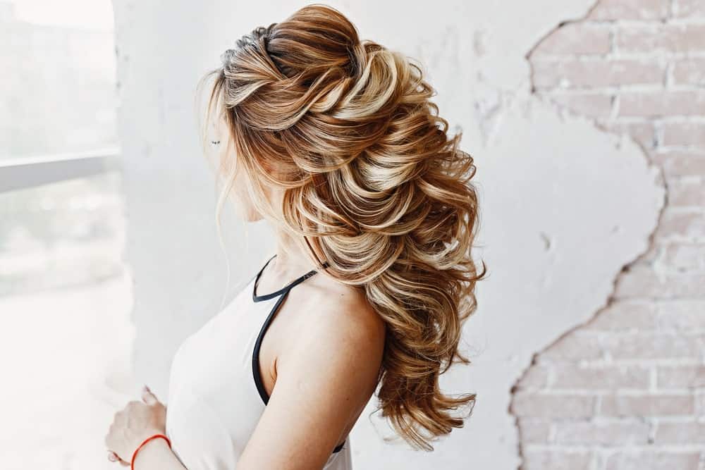 This hairstyle has tons of volume. With backcombing at the crowns and lots of voluminous curls, it adds height to any hairdo out there. 