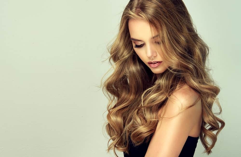 If you have heavy, thick dark blond hair, flaunt it by adding some lighter sun-kissed highlights to it. This gorgeous balayage is a blend of dark gold, caramel and red tones.
