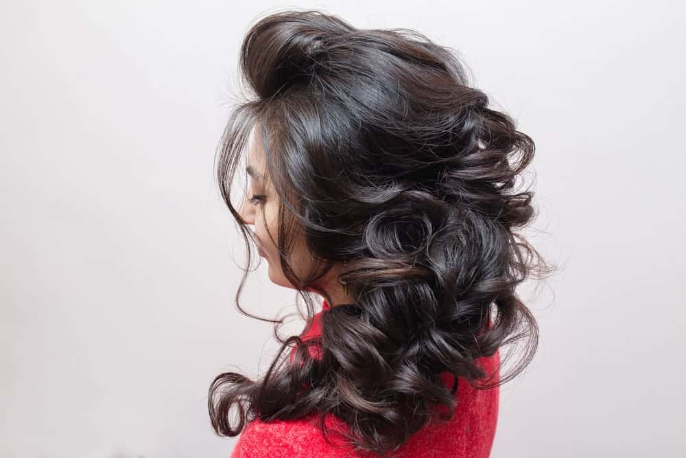 Gentle curls are the star of this hairdo. Sweeping the curls to one side gives an elegant, softer look.