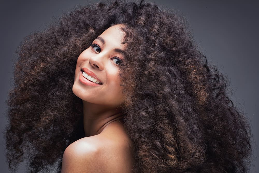 A smiling woman with dark brown kinky hair