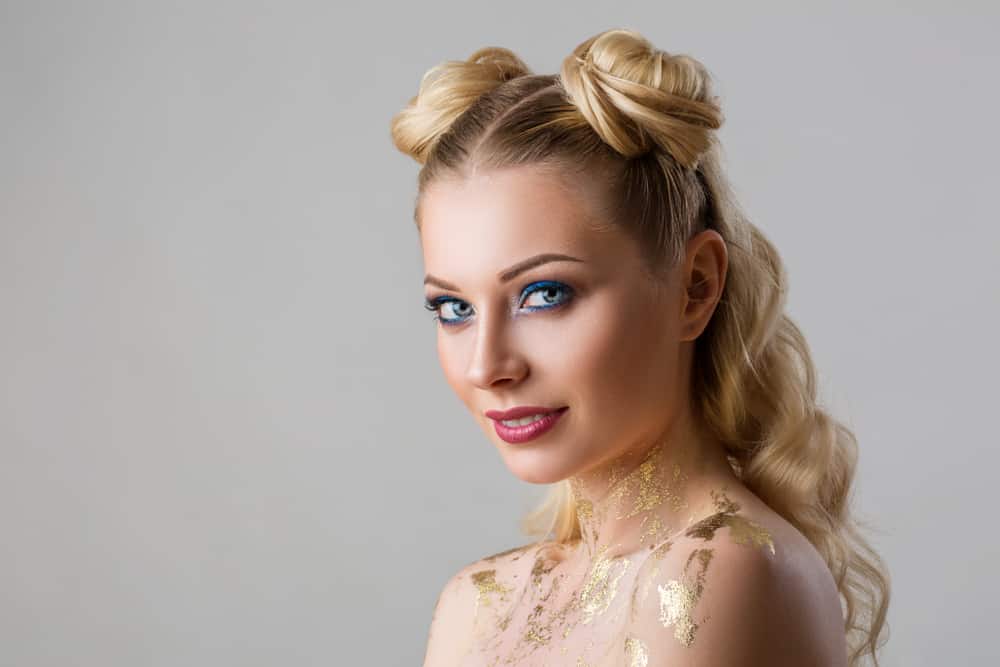 A young woman with side buns in her long curly blond hair