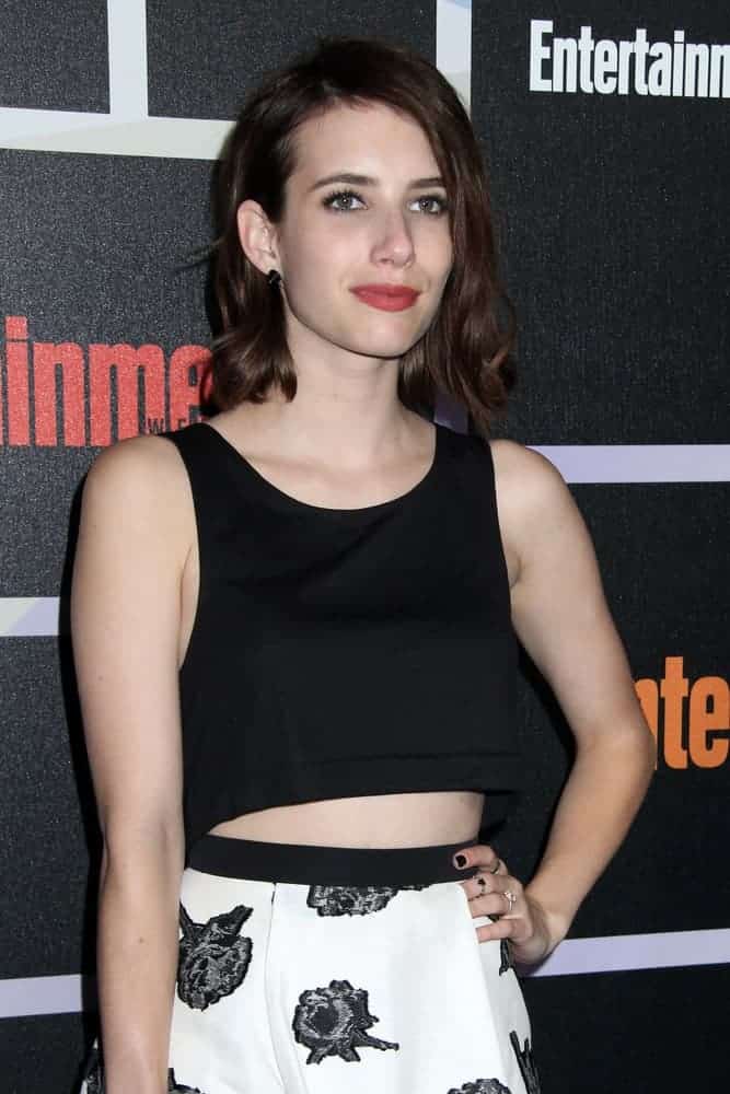 Emma Roberts was at the Entertainment Weekly Party - Comic-Con International 2014 at the Float at Hard Rock Hotel San Diego on July 26, 2014, in San Diego, CA. She wore a smart casual outfit with her shoulder-length dark and curly hairstyle that is tousled and loose.